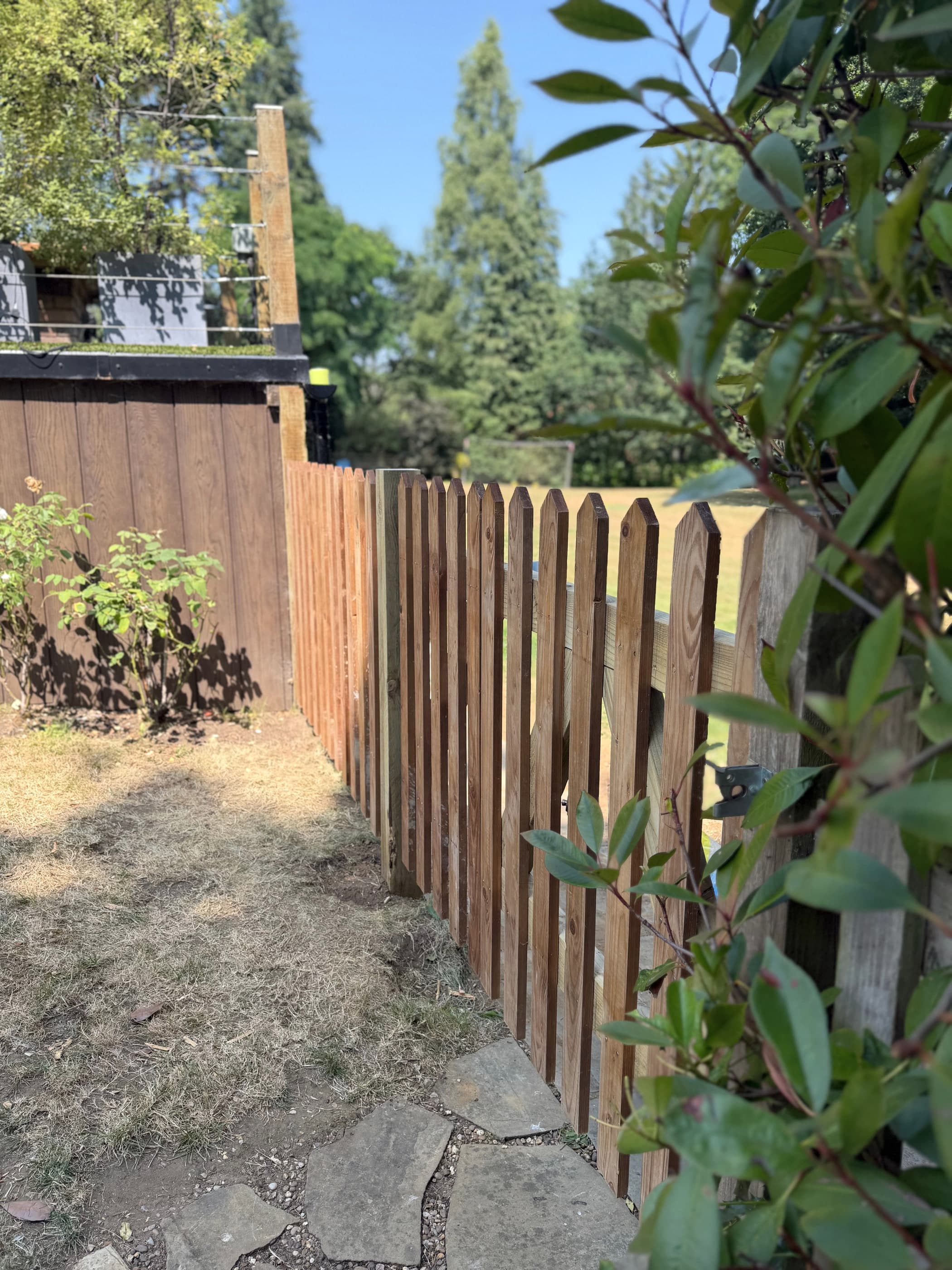 Run of pointed timber picket fencing along a garden boundary with parkland beyond