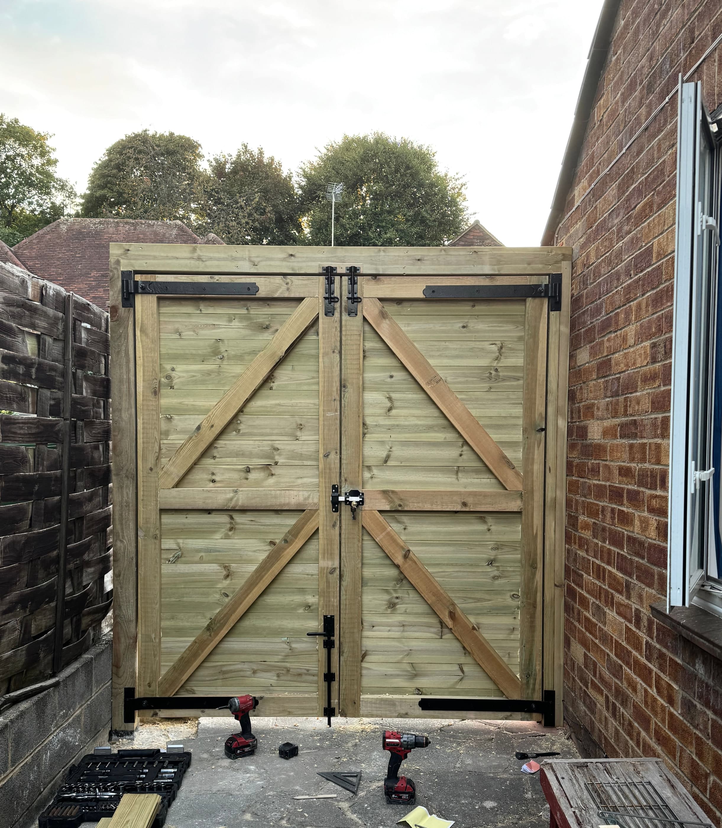 The same pair of side gates from the garden side, showing the ledges, braces and black japanned strap hinges