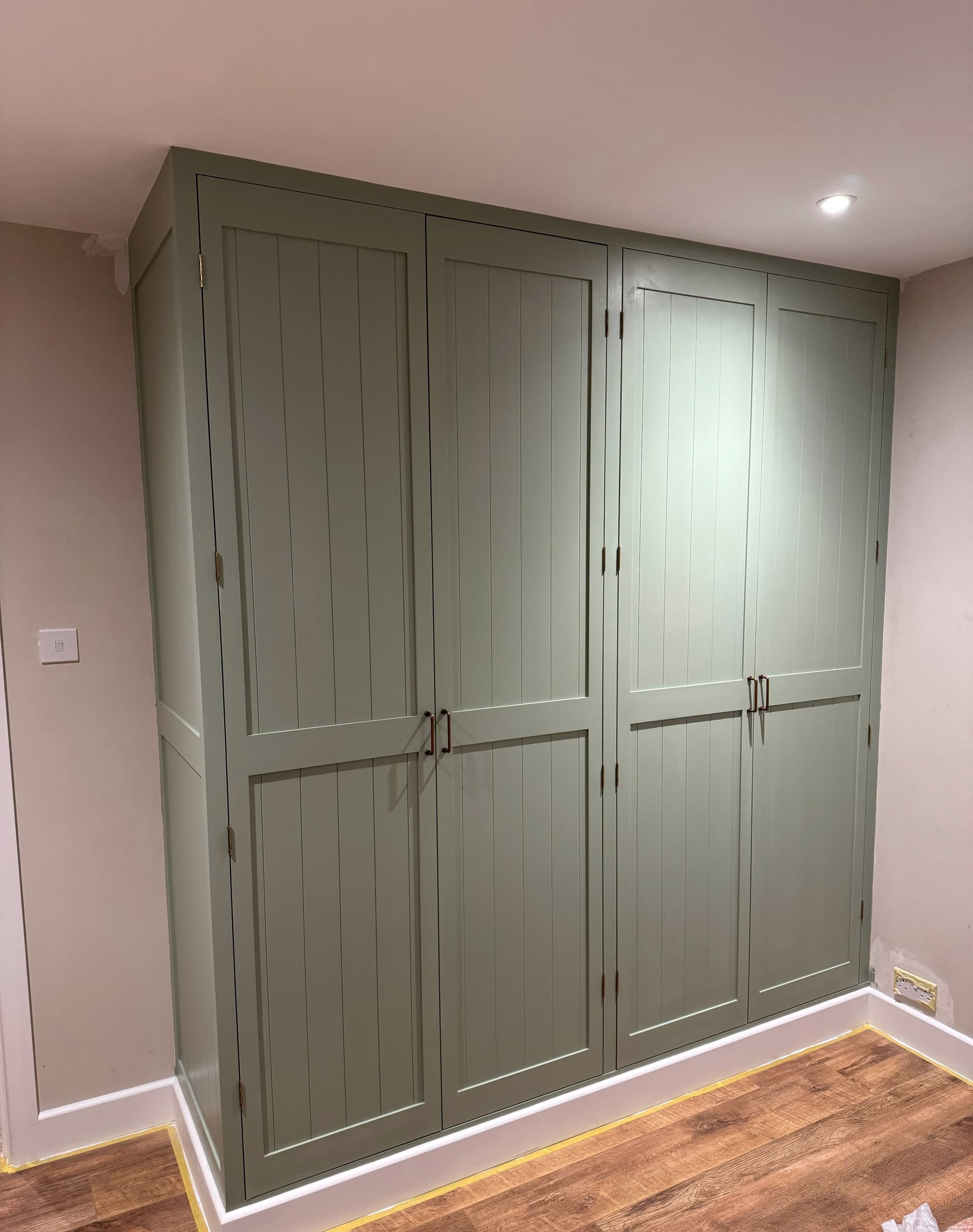 Bespoke sage-green fitted wardrobe built by RGS Carpentry