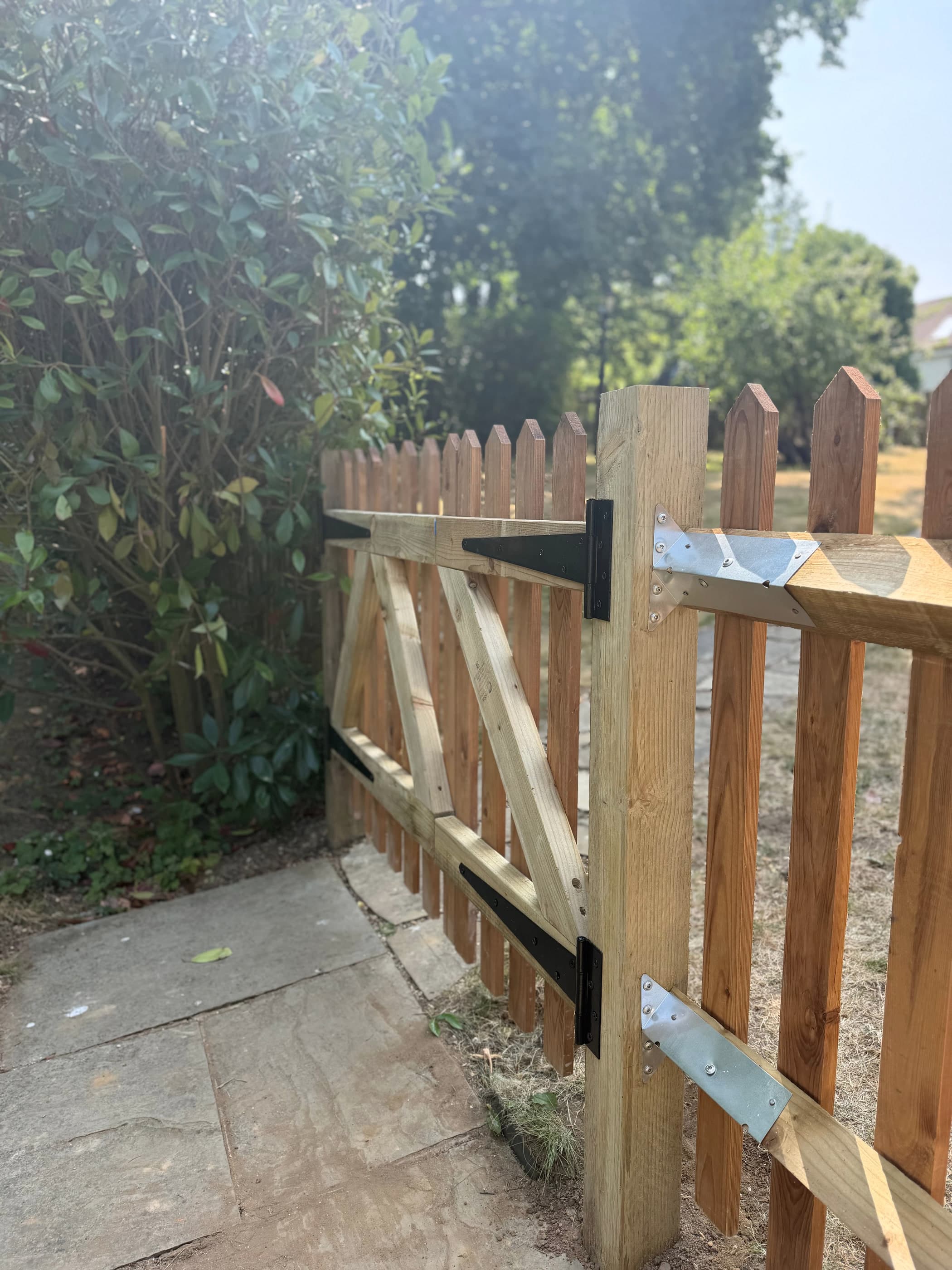 Detail of galvanised strap hinges and bracing on a bespoke timber picket gate